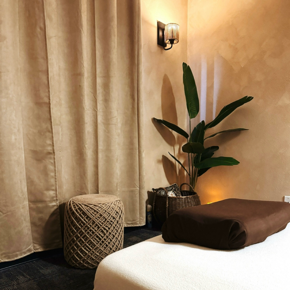 Massage bed with greenery and warm curtain lighting